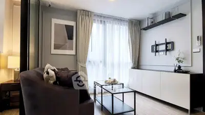 Modern living room with sleek furniture and large window, perfect for cozy gatherings.