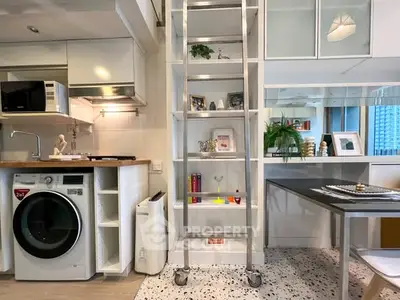 Modern compact kitchen with washing machine and ladder shelf in stylish apartment.