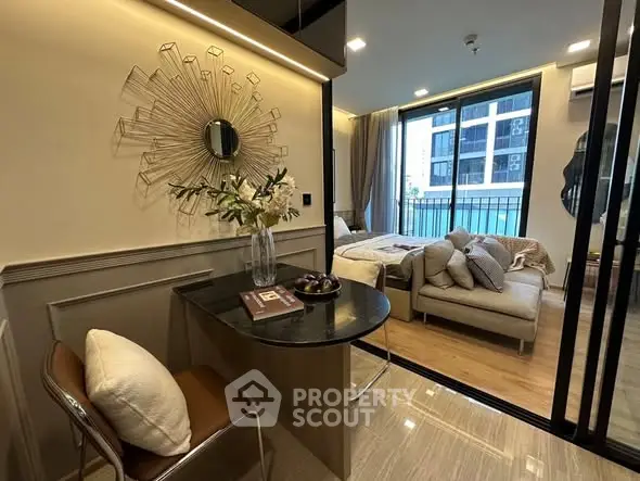 Modern studio apartment with stylish decor, featuring a cozy living area and a view of the cityscape.