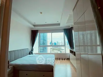 Spacious bedroom with city view in modern high-rise apartment