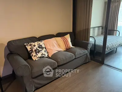 Cozy living room with stylish sofa and glimpse of bedroom, perfect for modern living.