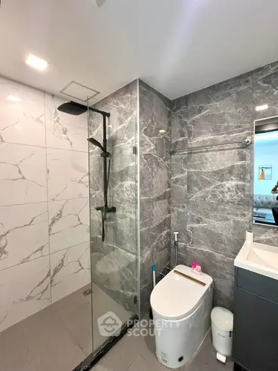 Modern bathroom with sleek marble tiles and glass shower enclosure