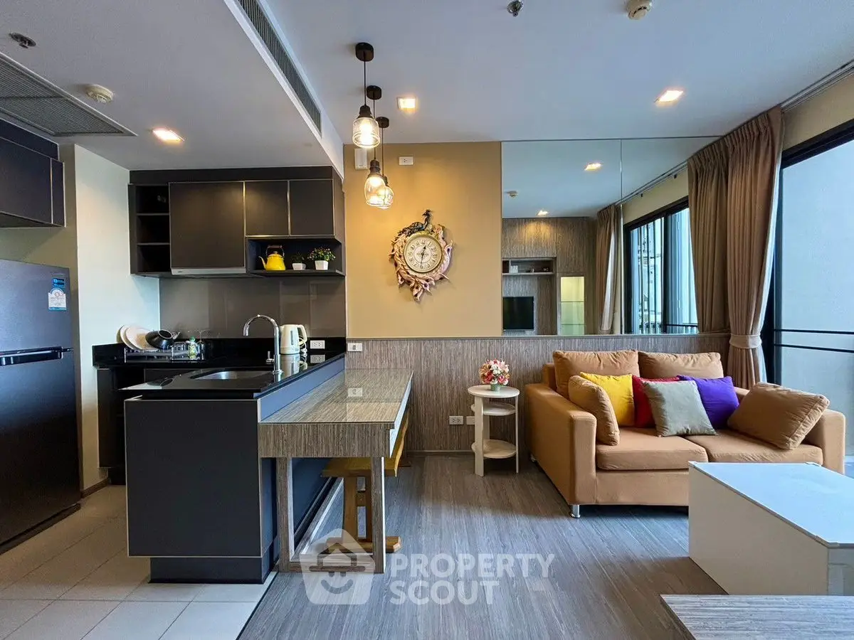 Modern open-layout living room with stylish kitchen and cozy seating area.