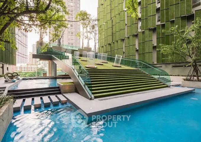 Luxurious modern building exterior with unique green facade and stunning pool area, perfect for urban living.