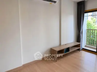 Spacious living room with wooden flooring and balcony view