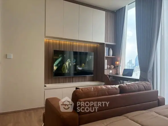 Modern living room with sleek TV setup and city view, featuring a cozy brown leather sofa and elegant decor.