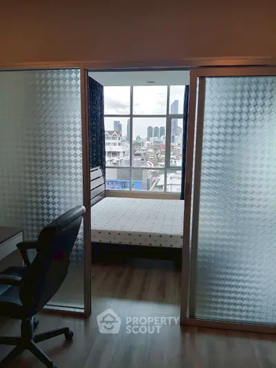 Modern bedroom with city view and sliding glass doors, perfect for urban living.