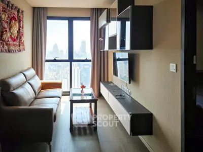 Modern living room with city view, featuring sleek furniture and large windows for natural light.