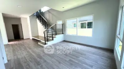 Spacious modern living room with elegant staircase and large windows