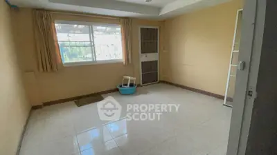 Spacious empty room with large window and tiled floor, ready for customization.