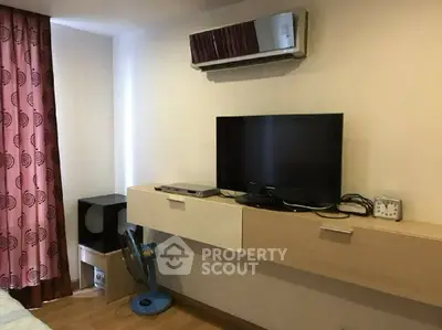 Cozy living room with modern TV setup and stylish wall-mounted shelf.