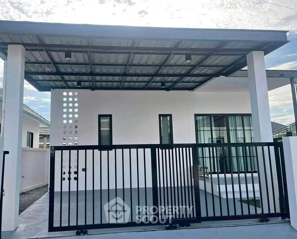 Modern single-story house with sleek metal gate and covered carport.