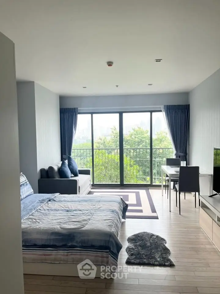 Modern studio apartment with large windows and balcony view