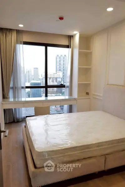 Modern bedroom with city view, featuring a large window and elegant furnishings.