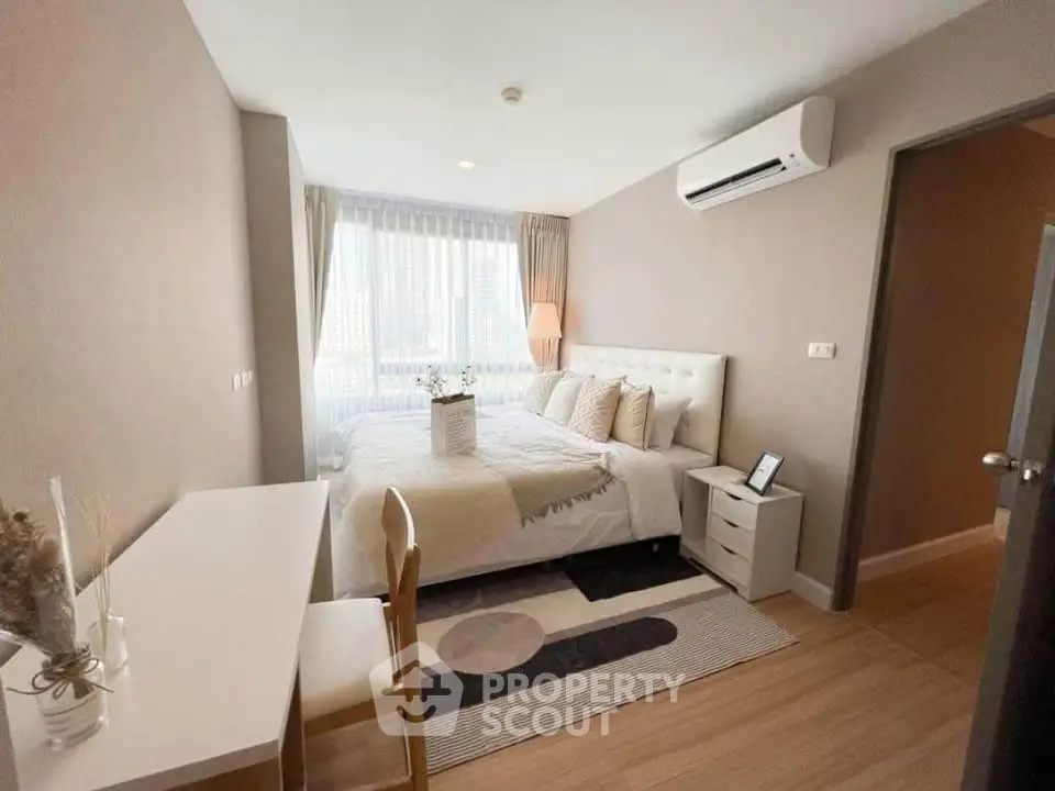 Cozy modern bedroom with natural light and stylish decor in a high-rise apartment.