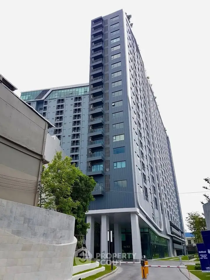 Modern high-rise building with sleek design and lush greenery, perfect for urban living.