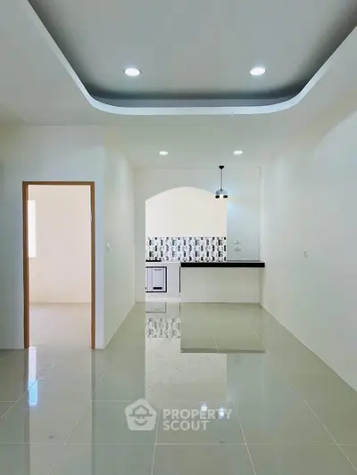 Modern open-layout kitchen with sleek design and ample natural light, perfect for contemporary living.