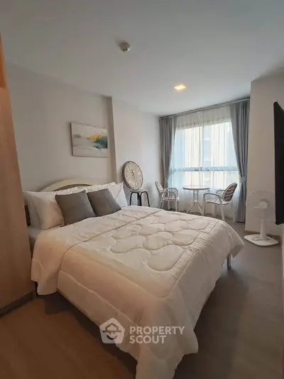 Cozy bedroom with modern decor and large window for natural light