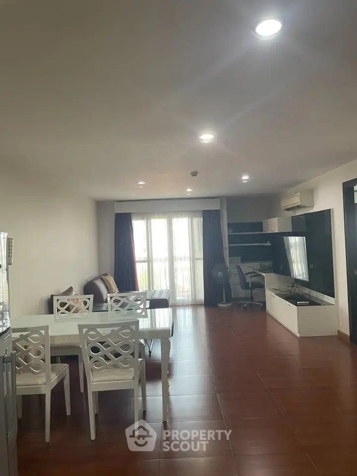 Spacious living room with modern furniture and natural light in a stylish apartment.