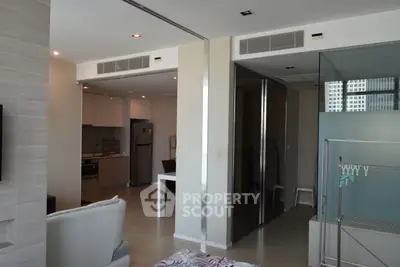 Modern open-plan living space with sleek kitchen and stylish decor in a high-rise apartment.