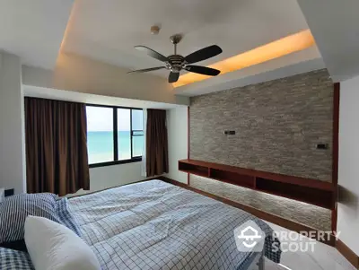 Stunning bedroom with ocean view and modern ceiling fan in luxury apartment