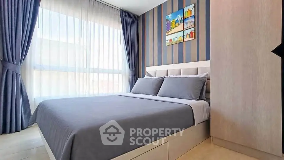 Modern bedroom with stylish decor and large window offering natural light.