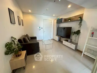 Modern living room with sleek furniture and large TV, perfect for relaxation and entertainment.