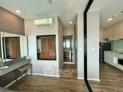 Modern apartment interior with sleek kitchen and cozy living area, featuring stylish decor and wooden flooring.