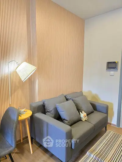 Modern living room with stylish gray sofa and wooden accents, perfect for cozy relaxation.