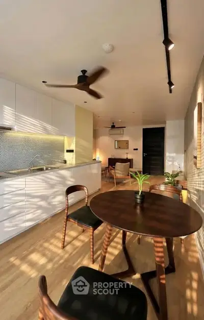 Modern open-layout kitchen and dining area with stylish furniture and natural lighting.