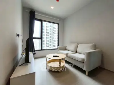 Modern living room with cozy sofa and large window offering city view.