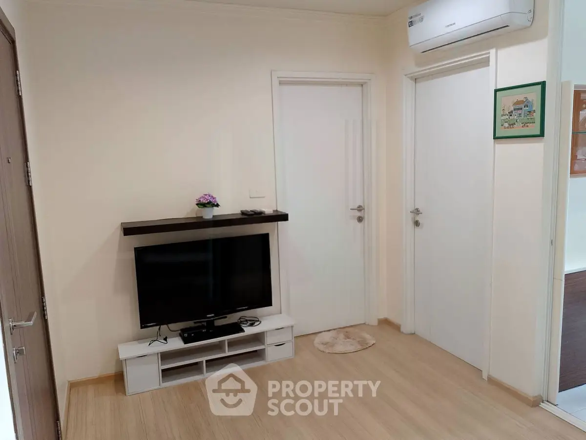 Modern living room with sleek TV setup and air conditioning, perfect for cozy relaxation.