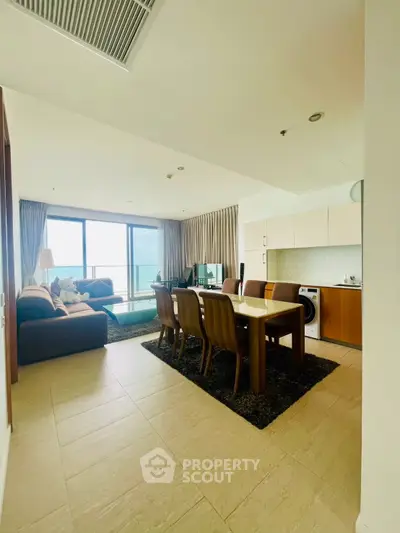 Spacious open-plan living and dining area with modern kitchen and stunning sea view.