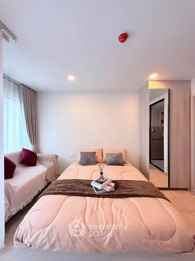 Cozy bedroom with modern decor and natural light, featuring a comfortable bed and stylish furnishings.
