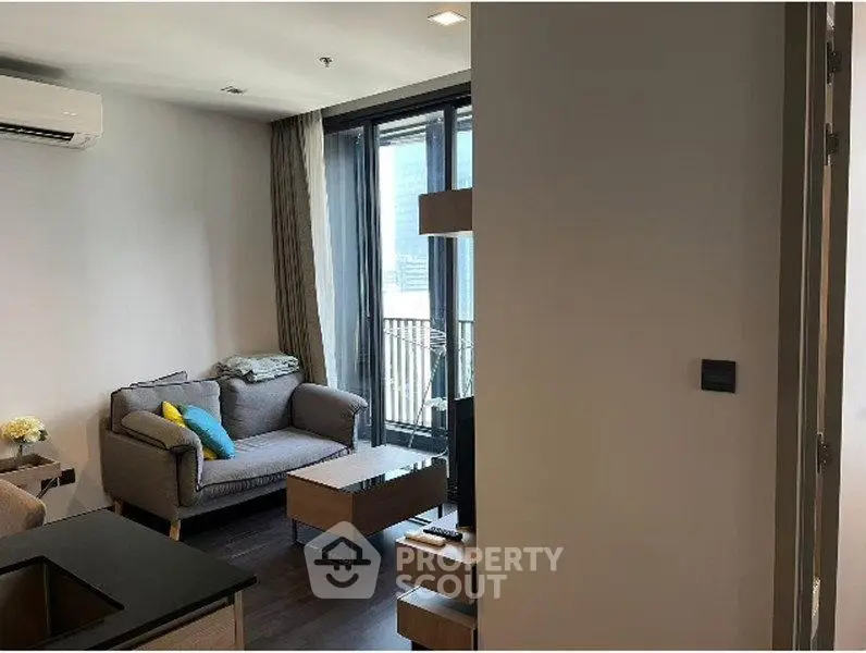 Modern living room with balcony access and stylish furniture in a cozy apartment.