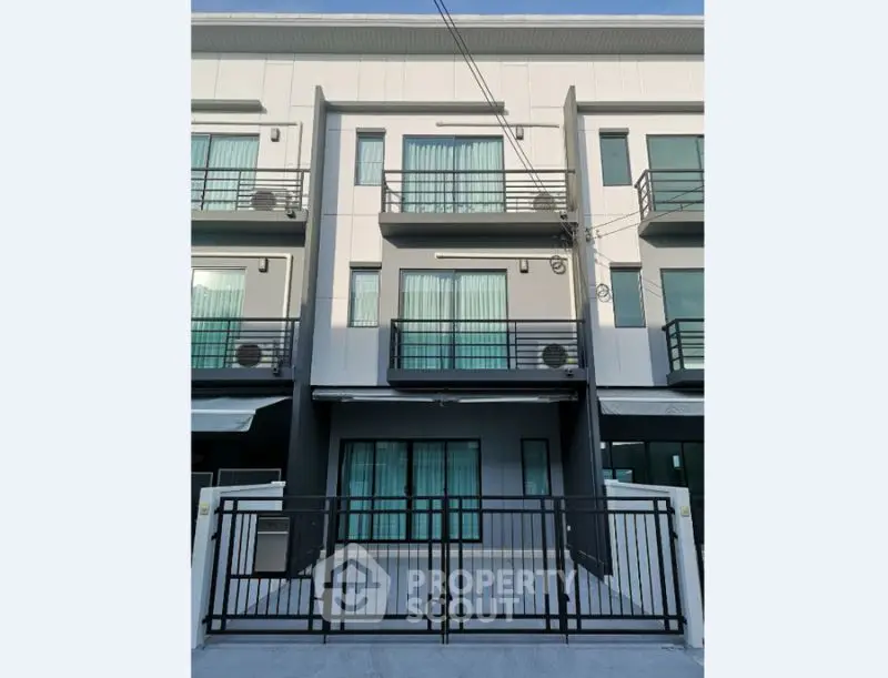 Modern townhouse exterior with sleek design and multiple balconies