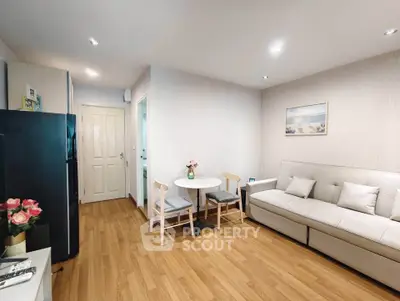Modern living room with cozy sofa and dining area, featuring elegant wooden flooring and stylish decor.