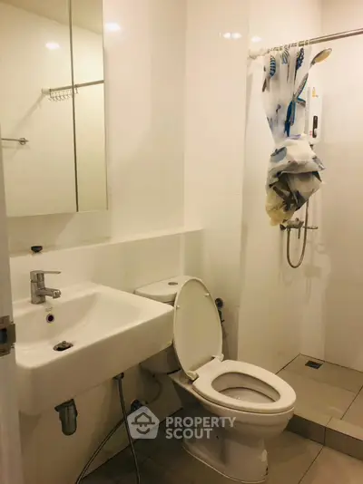 Compact bathroom with modern fixtures and shower in a real estate property.
