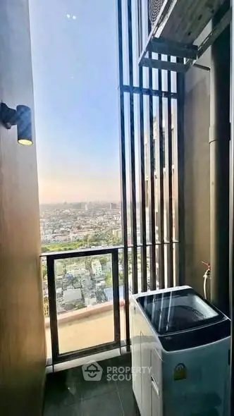 High-rise apartment balcony with stunning city view and washing machine setup.