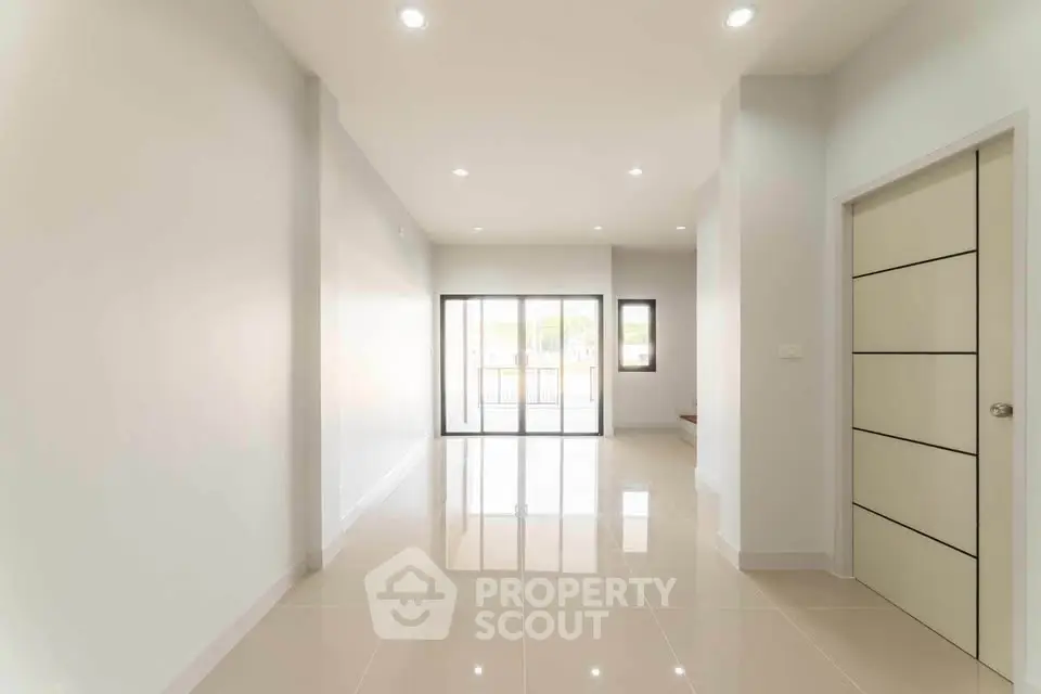 Spacious modern living room with glossy tiled floors and large windows.