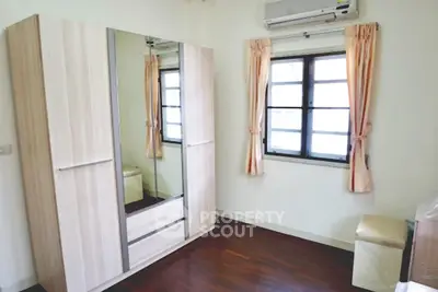 Cozy bedroom with mirrored wardrobe and wooden flooring