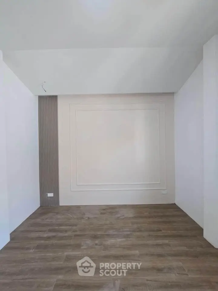 Minimalist empty room with wooden flooring and modern wall design