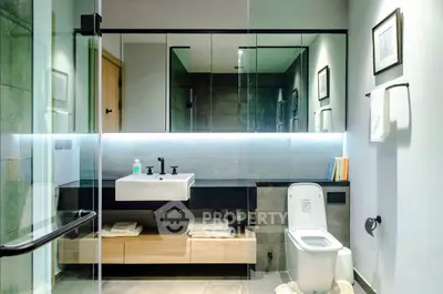 Modern bathroom with sleek design, glass shower, and elegant fixtures.