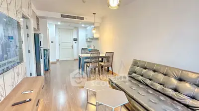 Modern living room with sleek furniture and open kitchen layout in a stylish apartment.