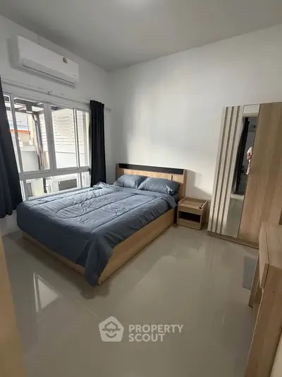 Modern bedroom with sleek furniture and natural light, perfect for a cozy retreat.