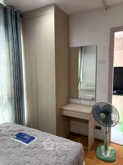 Cozy bedroom with wardrobe, vanity, and fan in a well-lit space.