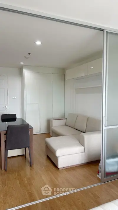 Modern living room with sleek furniture and sliding glass doors in a stylish apartment.