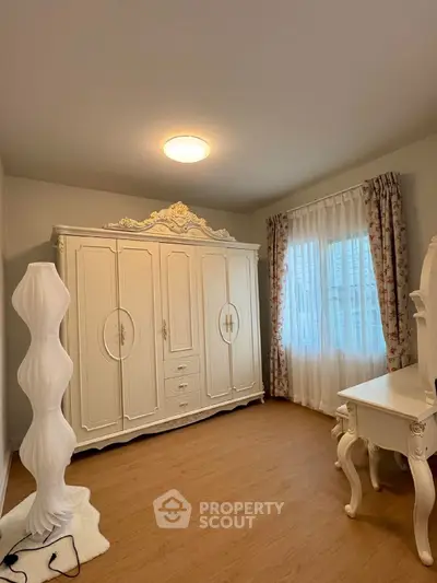 Elegant bedroom with vintage white wardrobe and ornate furniture