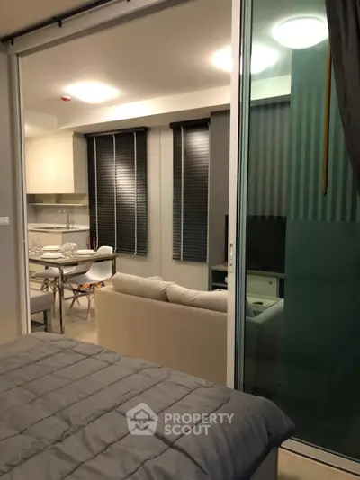 Modern open-plan living room with kitchen, featuring sleek design and cozy ambiance.