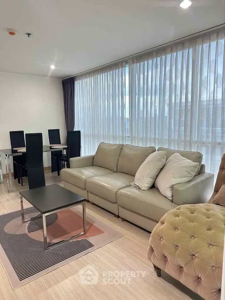 Spacious living room with modern furniture and large windows in a stylish apartment.